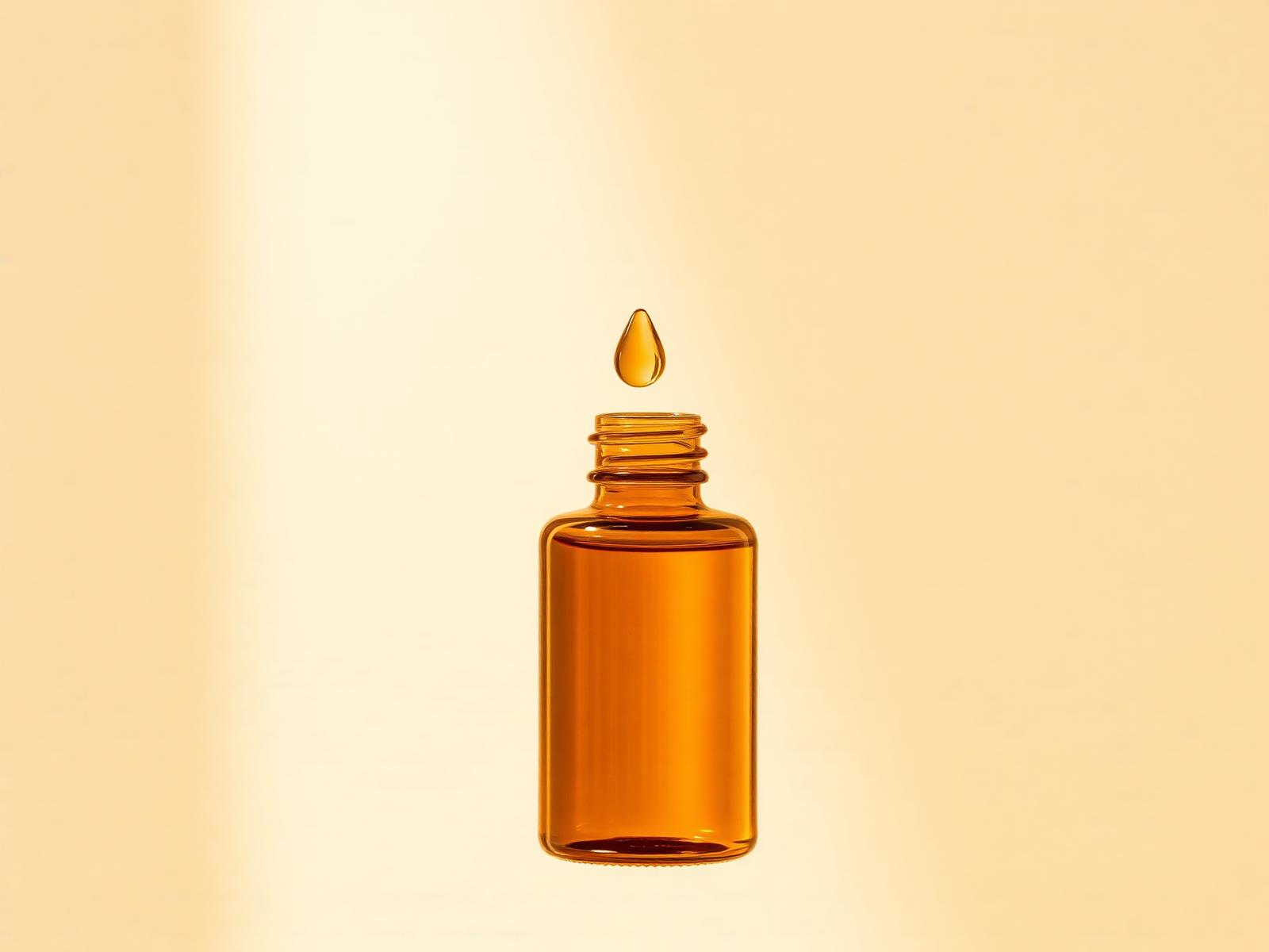 Light golden oat oil droplet suspended above a bottle